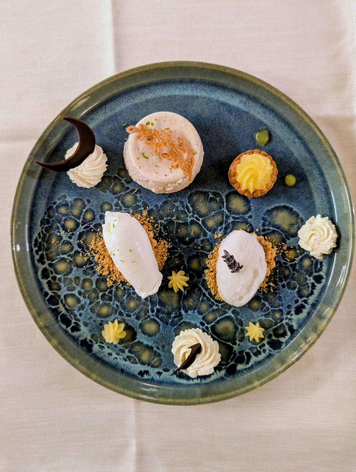 Blanc-manger aux amandes, sorbet à la lavande et petite tartelette, sur assiette bleue