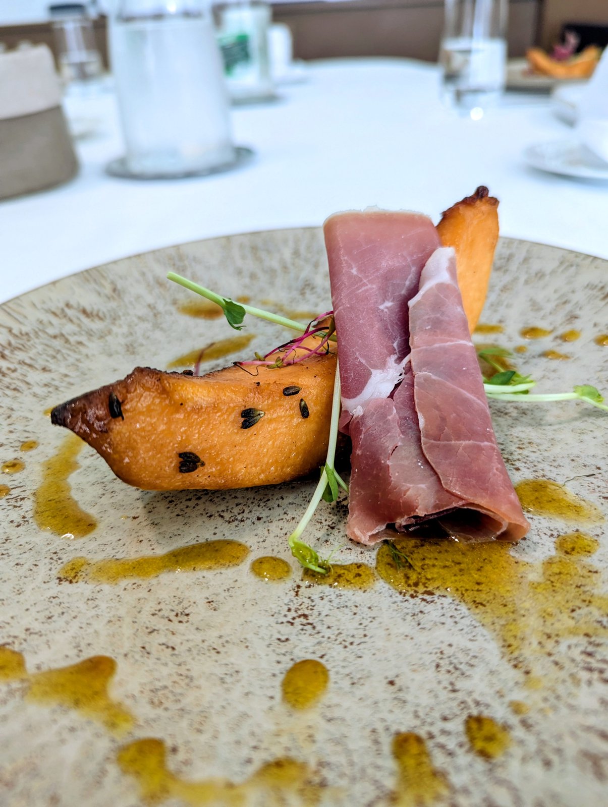 Melon rôti au miel de lavande et jambon cru, sur assiette en grès